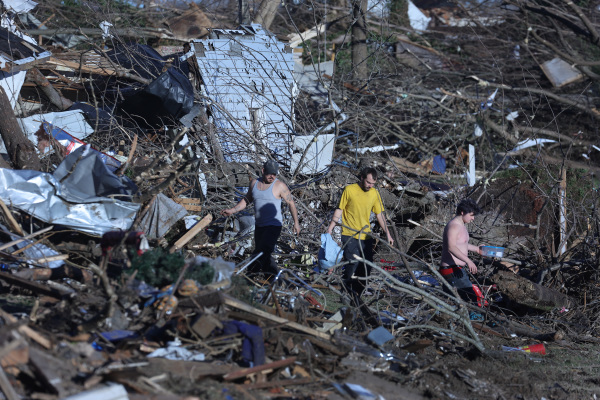 图为2021年12月12日，美国肯塔基州梅菲尔德市（Mayfield），居民们在被龙卷风摧毁后的自家废墟上寻找自己的物品。（图片来源：Scott Olson/Getty Images）