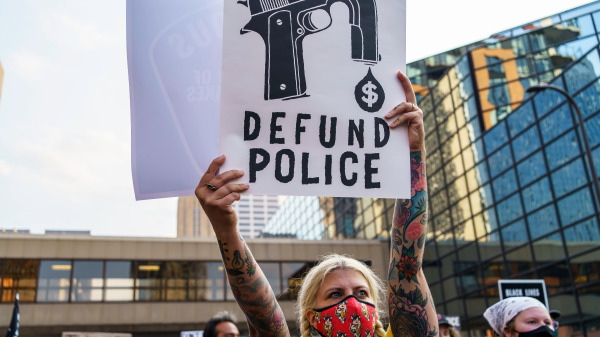 在美国明尼苏达州明尼阿波利斯举行的反对警察和种族主义的示威活动中，一名抗议者打出的“断资警察”的牌子