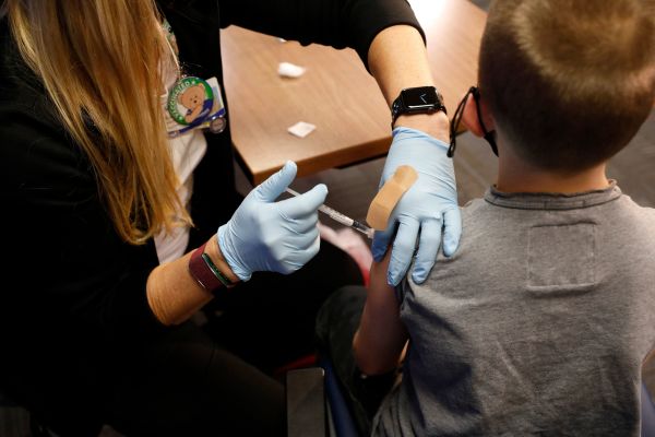 圖為2021年11月5日在芝加哥，一名8歲的男孩在接受抗新冠病毒的輝瑞疫苗接種。（圖片來源：JEFF KOWALSKY/AFP via Getty Images）