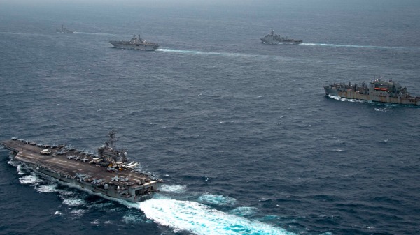 从左起，卡尔文森号、阿利伯克级导弹驱逐舰奥凯恩号、黄蜂级两栖攻击舰埃塞克斯号、哈珀斯费里级两栖登陆舰珍珠港号以及干货船USNS艾伦·谢泼德号，2022年1月13日过境中南国海。