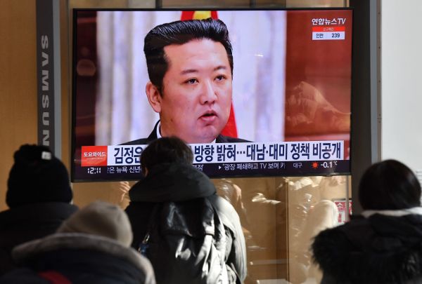 2022 年 1 月 1 日，人們在首爾火車站觀看電視新聞節目，該節目正播出金正恩出席朝鮮勞動黨中央委員會全體會議的照片。
