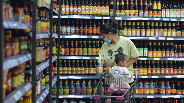 一名婦女帶著孩子在超市購物。