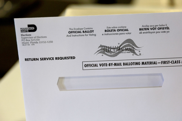 圖為2022 年 7 月 21 日，美國佛羅里達州邁阿密的邁阿密-戴德（Miami-Dade）郡的選舉部向媒體展示的郵寄投票的選票信封。當時，邁阿密-戴德郡選舉部在開始為2022 年 8 月 23 日的初選將國內郵寄選票郵寄給選民。（圖片來源：Joe Raedle/Getty Images）