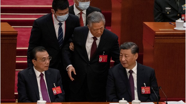 2022年10月22日，中共二十大闭幕式上，胡锦涛被工作人员带离会场。(图片来源：Lintao Zhang/Getty Images）
