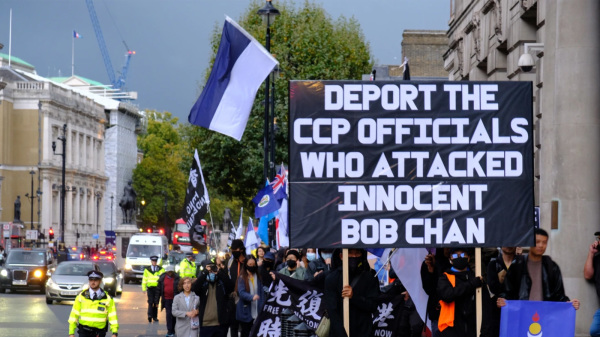10月23日，港人在倫敦舉行集會。抗議人士舉起一幅大型標語，要求「驅逐所有襲擊無辜示威者Bob Chan的中共官員」。（圖片來源：VOA）
