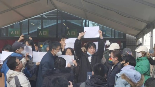 清华女生举着白纸抗议当局的清零封锁措施。(图片来源：推特截图)