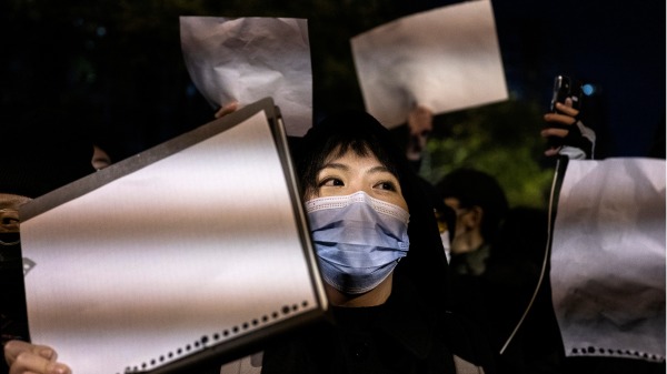 2022年11月27日，一位北京居民舉著白紙參加當地的一個集會，抗議中共當局。