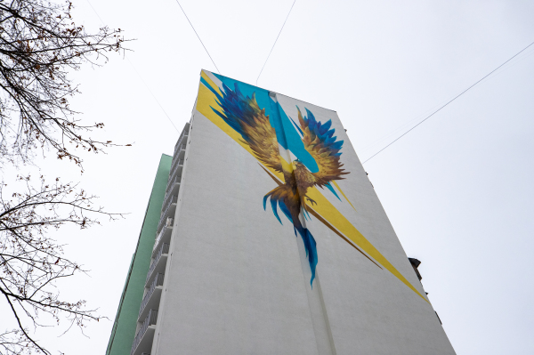 2022 年 12 月 7 日，烏克蘭首都基輔 Sviatoshynskyi 區一棟經過修復的高層住宅樓的外牆上出現了一幅鳳凰鳥的巨大壁畫，這只神話中的鳳凰鳥被用烏克蘭國旗的黃藍兩色繪畫而成，並展翅飛翔在烏克蘭國旗之上，這似乎象徵了戰火中的烏克蘭會涅磐重生的美好願望。（圖片來源：Oleksii Samsonov/Global Images Ukraine via Getty Images）