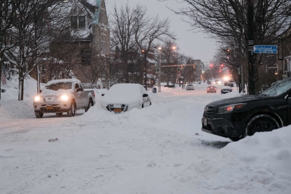 图为2022 年 12 月 26 日，美国纽约州西部地区布法罗（Buffalo）市的一条街道和上面的车辆被白雪覆盖。圣诞节期间，一场冬季风暴袭击了美国的大部分地区，而纽约州西部成为受灾最严重的地区。（图片来源：JOED VIERA/AFP via Getty Images）
