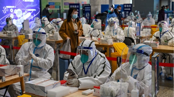 2022年12月6日，衛生工作者在抵達上海虹橋火車站後對乘客進行 COVID-19檢測。