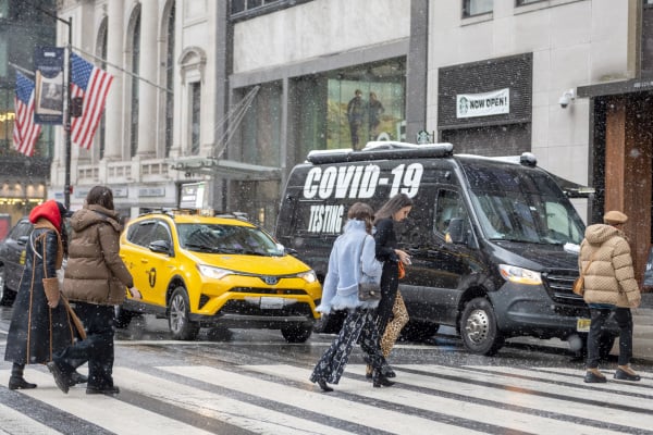 圖為2022年2月13日的紐約街頭，路邊停有一輛新冠病毒（COVID）檢測車，美國人已在新冠病毒的omicron變種感染中開始恢復正常生活。（圖片來源：Alexi Rosenfeld/Getty Images）