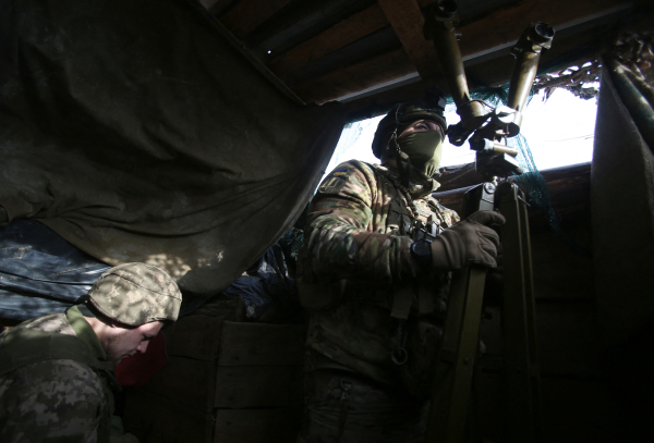 图为2022年2 月 17 日，乌克兰东部，乌克兰军队的前线阵地，一名军人在通过军事望远镜观察位于顿涅茨克（Donetsk）地区的亲俄叛军的活动情况，另一名军人在做记录。（图片来源：ANATOLII STEPANOV/AFP via Getty Images）