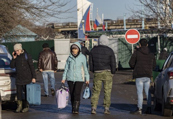 2022年2月19日，一些乌克兰东部的居民们携带着自己的财物和行李穿过位于阿维洛-乌斯彭卡（Avilo-Uspenka）的俄罗斯边境检查站，进入俄罗斯。这个与乌克兰接壤的俄罗斯地区于 2022 年 2 月 19 日宣布进入紧急状态，理由是越来越多的乌克兰人从亲俄分裂主义势力控制的乌克兰东部地区撤离并进入俄罗斯。（图片来源：ANDREY BORODULIN/AFP via Getty Images）