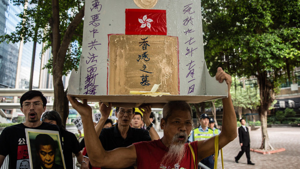 图为2015年7月1日，古思尧高举香港之墓在街头抗议。（图片来源：Getty Images）