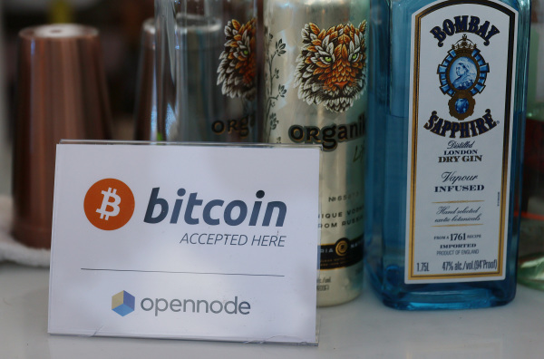 图为2021年6月4日，在美国佛罗里达州迈阿密举行 “2021比特币大会”（Bitcoin 2021 Convention）期间，一个酒吧里摆出“这里接受比特币”的标志。（图片来源： Joe Raedle/Getty Images）