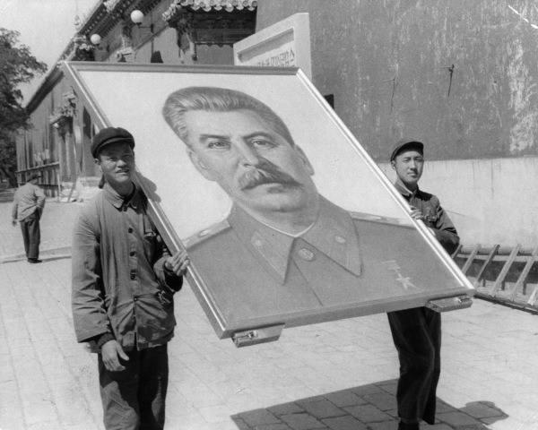 1956年5月，北京街头两位青年人抬着斯大林巨幅画像。（图片来源：Pictorial ParadeArchive PhotosGetty Images）