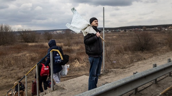 2022年3月7日，烏克蘭居民手持白旗從一座被毀的橋樑逃離激戰。