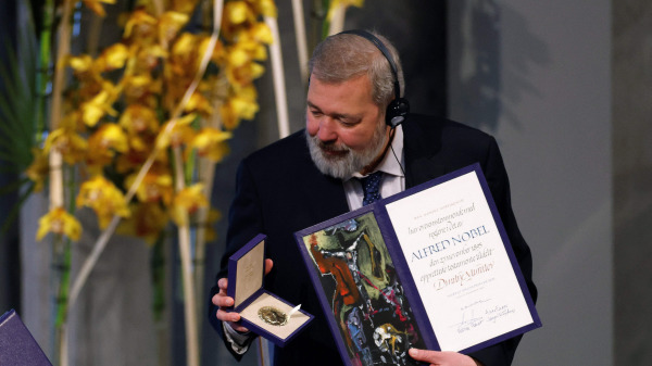 在挪威奥斯陆举行的颁奖典礼上，诺贝尔和平奖获得者俄罗斯的德米特里．穆拉托夫（Dmitry Muratov）手持诺贝尔和平奖证书和奖章留念。
