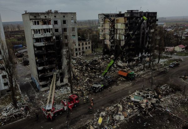 圖為2022年4月8日，烏克蘭首都基輔西北部的小鎮博羅季安卡（Borodianka），烏克蘭市政工人在一片建築物廢墟中用機械設備清理瓦礫。圖中的民用建築是被俄軍砲彈擊中毀壞的。（圖片來源：RONALDO SCHEMIDT/AFP via Getty Images）