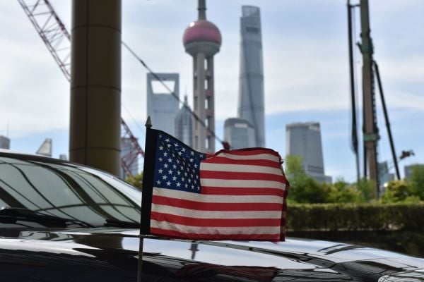 图为2019 年 7 月 31 日，一辆美国驻上海总领事馆的轿车上飘扬着美国国旗驶过上海外滩，背景是上海陆家嘴金融区的地标性摩天大楼。（图片来源：GREG BAKER/AFP via Getty Images）