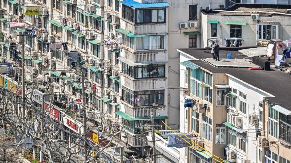 上海极端清零政策下，有人跳楼自杀。图为一小区楼顶，有两个人站在楼顶边缘。