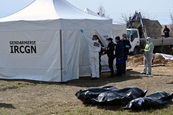2022年4月14日，烏克蘭首都基輔西北部郊區小鎮布查（Bucha），來自法國國家犯罪研究所（IRCGN）的法國調查人員和法醫在臨時搭建的帳篷裡檢查從布查和周邊地區屍體坑裡發現的數十具平民屍體。烏克蘭表示，自從俄羅斯軍隊撤走後，他們在布查和其它一些城鎮已經發現了1,222具平民屍體。（圖片來源：SERGEI SUPINSKY/AFP via Getty Images）