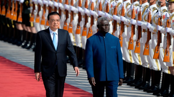 2019年10月9日，在北京人民大會堂舉行的歡迎儀式上，所羅門群島總理馬納西•索加瓦雷（右）和中國國務院總理李克強檢閱儀仗隊。