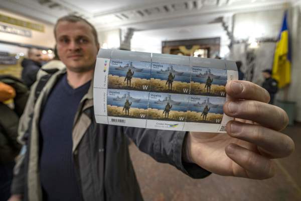 2022年4月15日，在乌克兰基辅市中心的一家邮局，一位当地居民展示他刚购买的乌克兰纪念邮票。