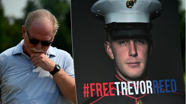 2021年7月29日，被俄羅斯判處9年監禁的美國前海軍陸戰隊隊員特雷弗．里德的父親站在兒子的海報前。(Tre JIM WATSON/AFP via Getty Images)