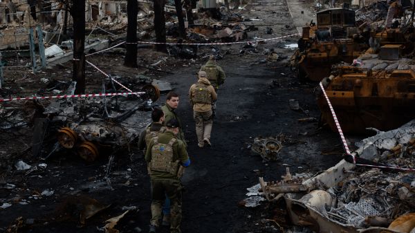 一隊烏克蘭軍人走在基輔郊區小鎮布查（Bucha）被燒燬的街道上。烏克蘭政府指控俄羅斯軍隊在佔領這座小鎮時對平民實施了「蓄意的大屠殺」。