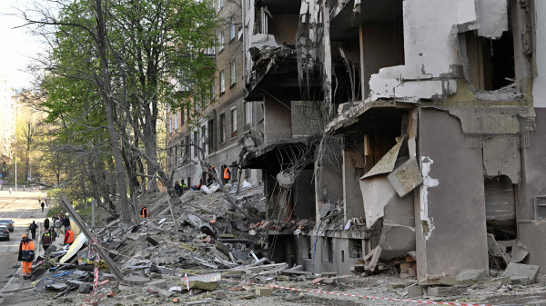 圖為2022年4月29日，在俄羅斯入侵烏克蘭期間，烏克蘭公共工作人員正在清理基輔一座受到轟炸的高層建築物周圍的碎片
