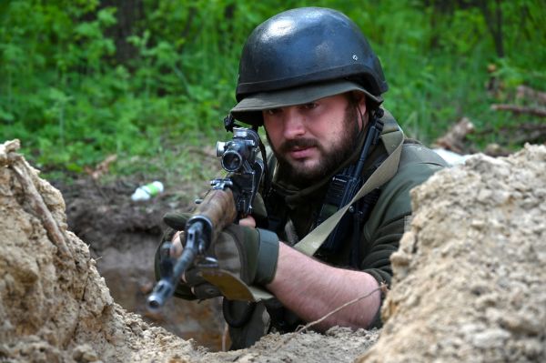 2022年4月30日，在距離烏克蘭第二大城市哈爾科夫不遠的地方，一名烏克蘭軍人持槍守在戰壕邊上。
