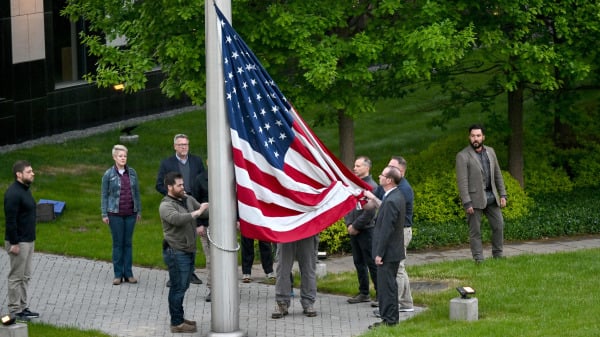 員工在美國駐基輔大使館外升起美國國旗。此時，美國大使館因俄羅斯全面入侵烏克蘭已經關閉了3個月。