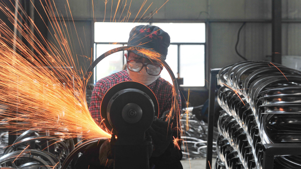 2022年4月17日，一名工人在中國浙江省東部杭州市的一家工廠焊接車輪。