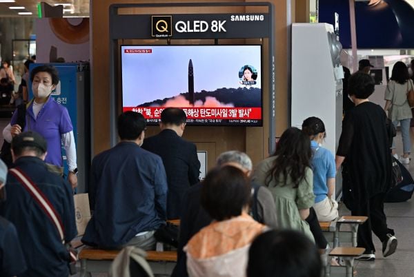 图为2022 年 5 月 25 日，韩国首尔一个火车站里的电视屏幕上在播放朝鲜于24日向日本海发射三枚弹道导弹的新闻，其中一枚是洲际弹道导弹。（图片来源：JUNG YEON-JE/AFP via Getty Images）