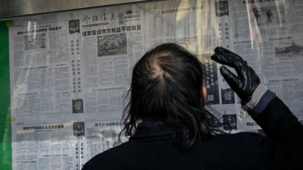 2022年2月24日，一名男子在北京的一條街道上閱讀報導俄羅斯和烏克蘭衝突的中國官方報紙