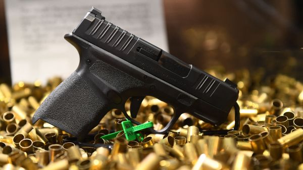 2022 年 5 月 28 日，在美國德克薩斯州休斯頓舉行的全國步槍協會（NRA）年會上展示的一把已經發射了2萬發子彈的 Springfield Armory Hellcat 9 毫米微型手槍和空彈殼。在美國槍擊案頻繁的情況下，左派人士們推動嚴格限制槍支，而保守派人士們則推動允許人們可以在不需要許可證的情況下隱蔽攜帶手槍以在萬一的情況下可以自衛。（圖片來源：PATRICK T. FALLON/AFP via Getty Images）