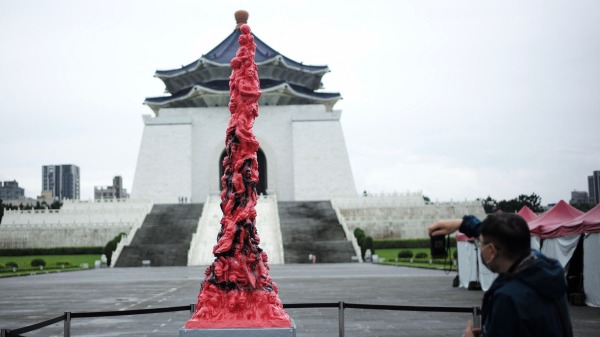 2022年6月12日，台北中正紀念堂前，一名遊客在被黑漆污損後為恥辱柱拍照