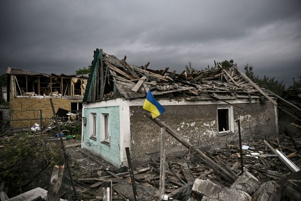 2022 年 6 月 15 日，烏克蘭東部頓巴斯地區的多布羅皮利亞（Dobropillia）市遭到俄羅斯軍隊砲擊發，當地居民把一面烏克蘭國旗插在被毀的房屋前以示抵抗俄羅斯的決心。（圖片來源：ARIS MESSINIS/AFP via Getty Images）