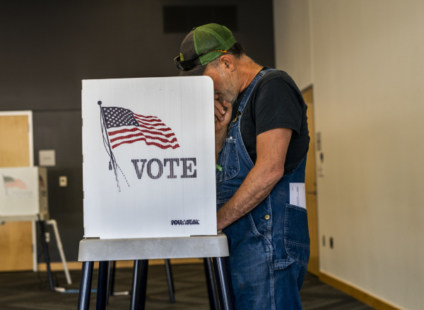 2022 年 6 月 7 日，美国中期选举在加利福尼亚州、爱荷华州、密西西比州、蒙大拿州、新泽西州、新墨西哥州和南达科他州举行初选。图为爱荷华州艾姆斯（Ames）的一位选民在艾姆斯公共图书馆投票站里填写选票。（图片来源：Stephen Maturen/Getty Images）