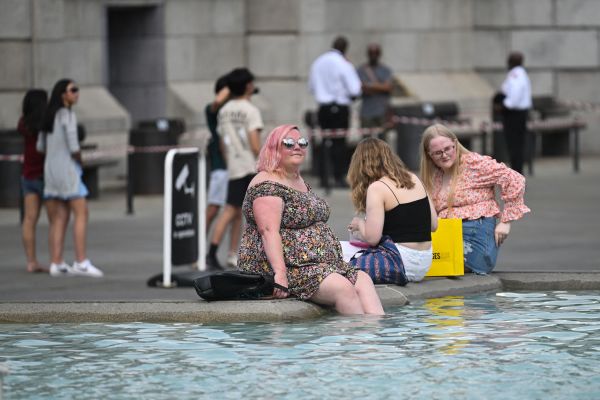 2022年7月13日，在熱浪中，倫敦市中心特拉法加廣場有行人將腳放到噴泉的水中降溫。