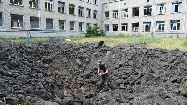 2022年7月7日，一名乌克兰军人在哈尔科夫的一所为盲人儿童设立的寄宿学校检查一个巨大的弹坑。