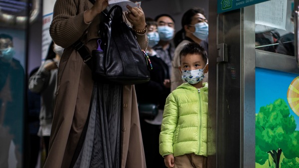 2021年11月18日，一名儿童戴着口罩在武汉接种疫苗