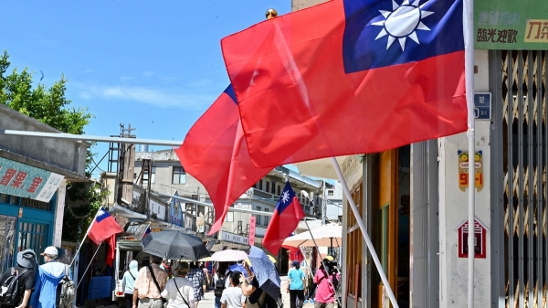 台湾金门群岛的游客走过台湾国旗