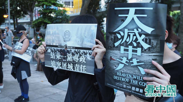 2020年六四當晚香港市民自發到維園悼念六四。圖為兩名市民手持結束一黨專政，追究屠城責任和天滅中共的海報。（攝影：龐大衛/看中國）