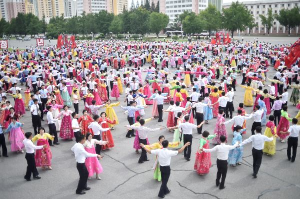 圖為2022 年 8 月 25 日，朝鮮年輕人和學生在平壤體育館前的大廣場上集體盛裝跳舞，以紀念朝鮮政權第二代領導人金正日首次實地指導革命武裝部隊62 週年。（圖片來源：KIM WON JIN/AFP via Getty Images）