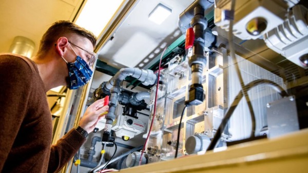 2021 年，一名员工在美国太平洋西北国家实验室的电池可靠性实验室查看钒液流电池。 （Andrea Starr/太平洋西北国家实验室）