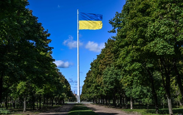 图为2022 年 9 月 19 日拍摄的照片，在俄罗斯入侵乌克兰期间，乌克兰国旗在顿涅茨克（Donetsk）地区克拉马托尔斯克（Kramatorsk）的一个公园里高高飘扬。莫斯科计划于9月30日正式将顿涅茨克和另外三个乌克兰领土——卢甘斯克、扎波罗热和赫尔松——吞并入俄罗斯联邦，这被认为是二战以来最大规模的非法土地掠夺。 （图片来源：JUAN BARRETO/AFP via Getty Images）