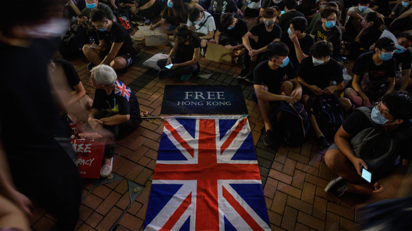 图为2019年6月，反送中抗争者聚集在维港码头，地上展示一面英国国旗。（图片来源：Getty Images）