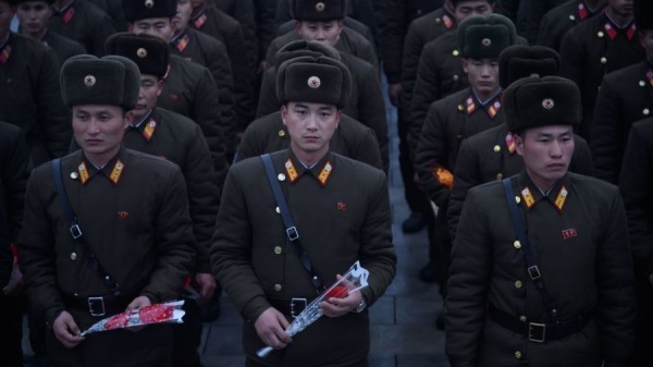 在 2019 年 12 月 17 日拍摄的一张照片中，朝鲜人民军士兵在平壤万寿山已故朝鲜领导人金正日逝世周年纪念日的雕像前手持鲜花。